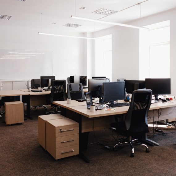 IT open space office. Computer Work Stations. Office Workplace with windows.